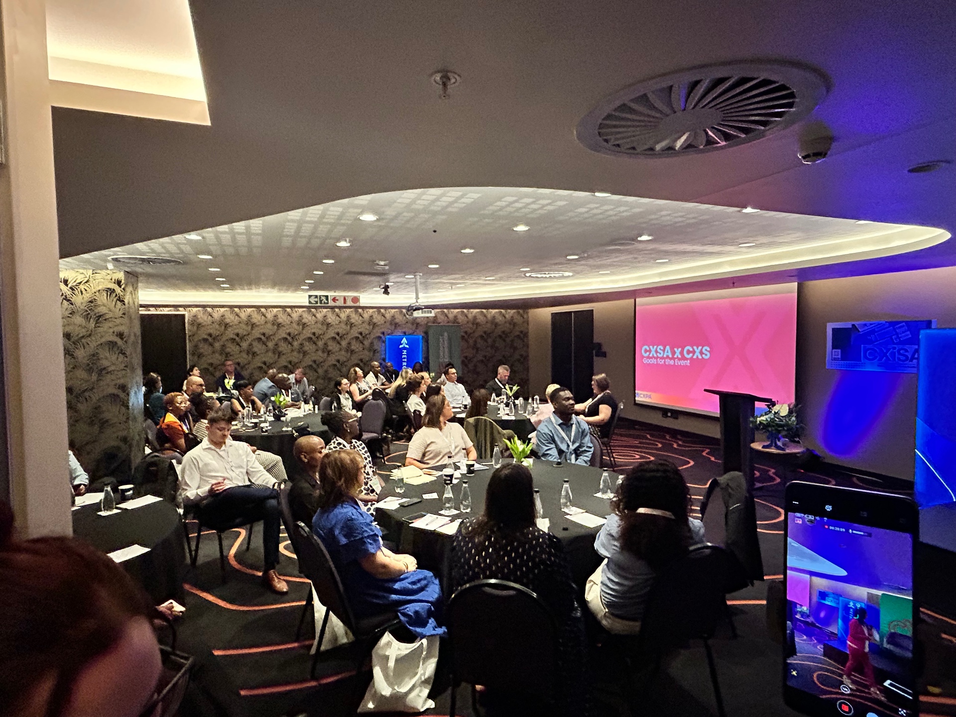CXS Experience Symposium branded main stage with panel seating